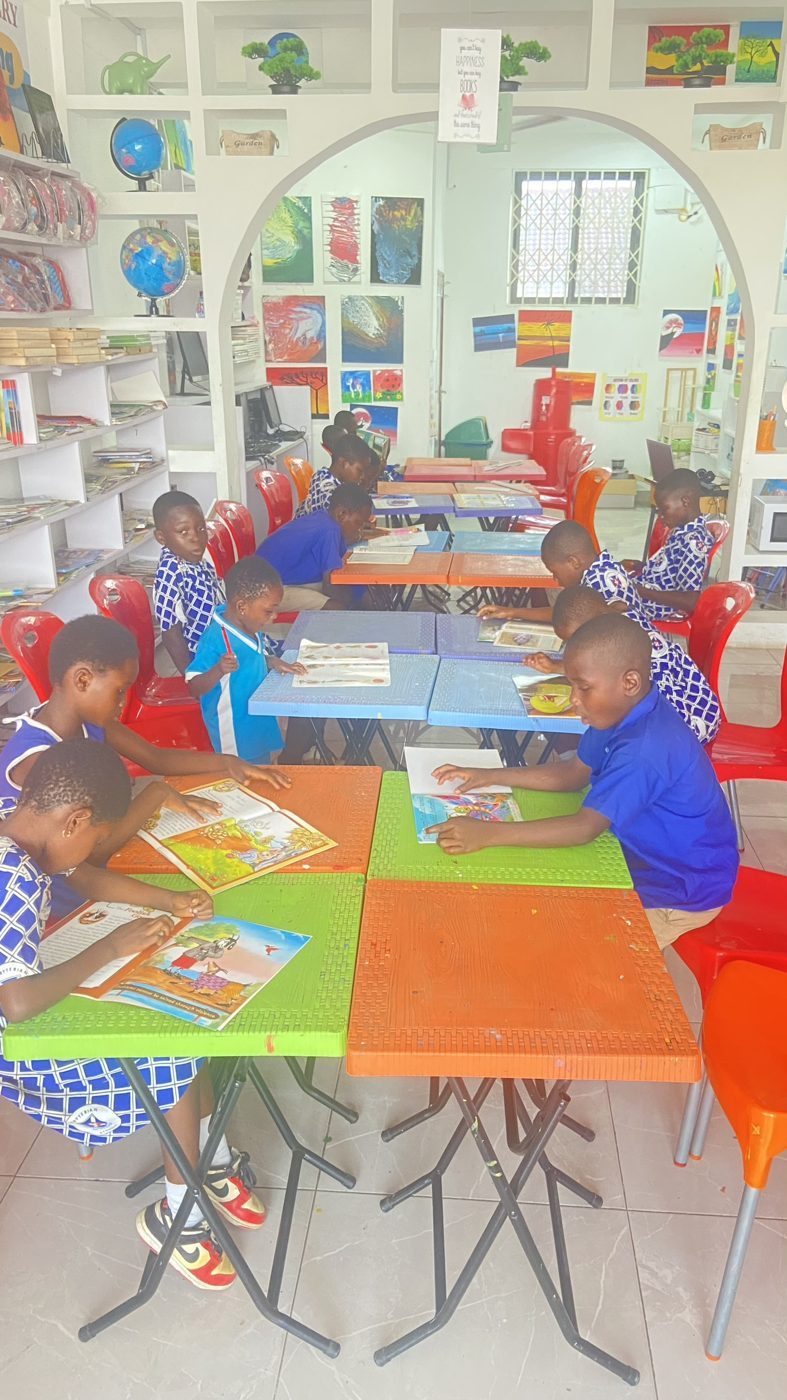 Students reading and using computers at the Books for Thought Library